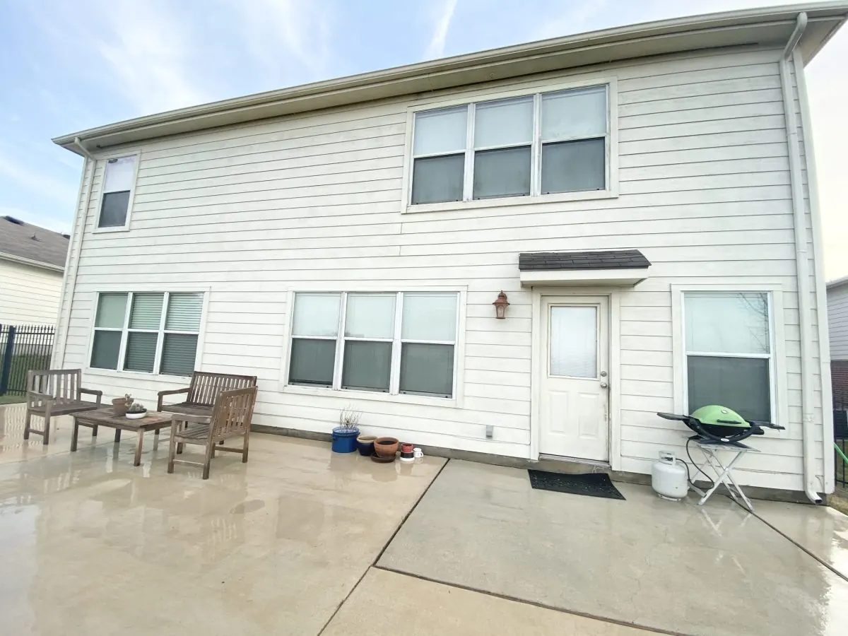 Same house after surface cleaning with clean siding and patio
