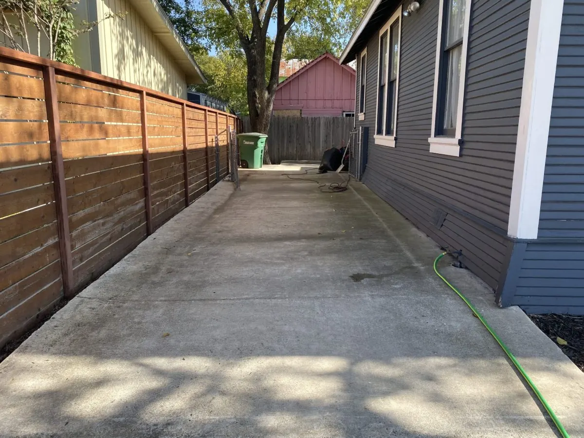 Clean concrete side yard and wood fence after surface cleaning
